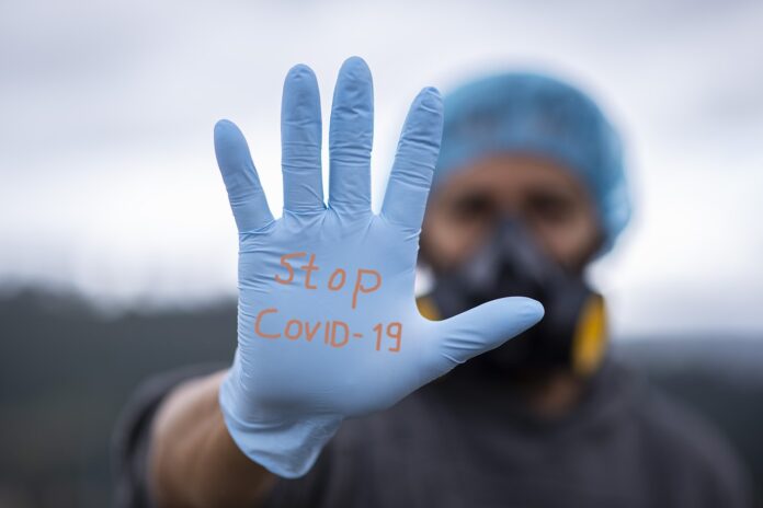 mano aperta con guanto, stop covid-19, test smart