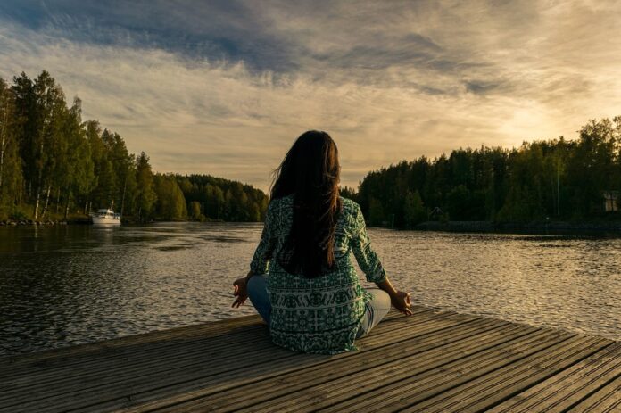meditazione-donna-vitriol-voce-interiore dona medita davanti ad un lago. Vitriol, viaggio interiore