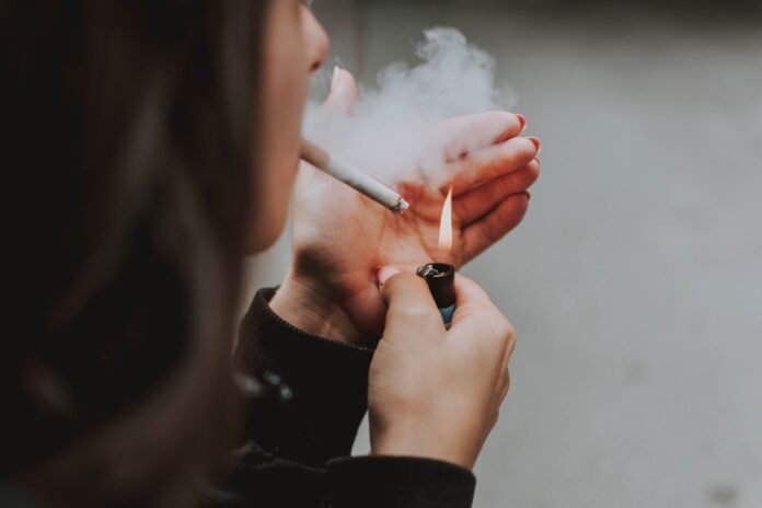 nicotina-tabagismo-ragazza-fuma ragazza si accende una sigaretta, nicotina tabagismo