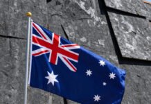 Bandiera australiana accanto a lastre di amianto eternit, composizione realistica, forte contrasto visivo, sfondo semplice ( immagine free generato da CANVA)
