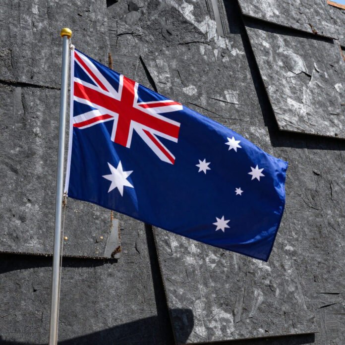 Bandiera australiana accanto a lastre di amianto eternit, composizione realistica, forte contrasto visivo, sfondo semplice ( immagine free generato da CANVA) Bandiera australiana accanto a lastre di amianto eternit, composizione realistica, forte contrasto visivo, sfondo semplice ( immagine free generato da CANVA)